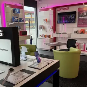 Modernes Telekom-Shop-Innenraum mit Samsung Smartphones, Zubehör und Magenta TV Beratung.