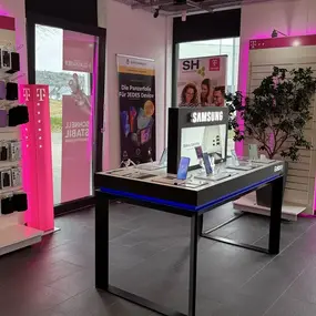 Modernes Telekom-Shop-Interieur mit Smartphones, Handy-Zubehör und Samsung-Präsentation.
